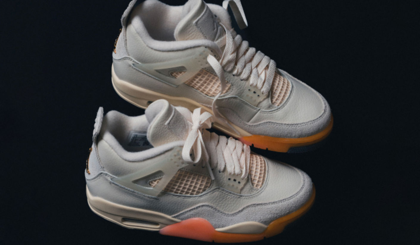 Air Jordan 4 WMNS Birds of Paradise sneakers in soft sail and light grey tones, featuring premium leather uppers, translucent accents, and gradient orange outsole details, showcased against a dark background.