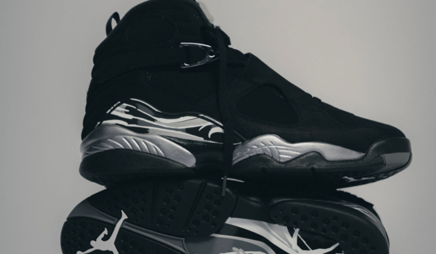 Air Jordan 8 Retro Chrome sneakers in black nubuck with reflective chrome accents and signature mid-top construction, showcased in a clean studio setting.