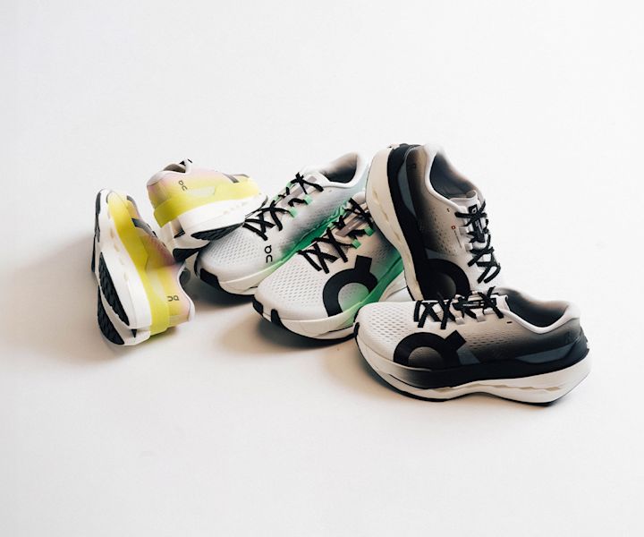 "Three pairs of On Cloudboom Max running shoes in different colorways — yellow-pink, green-white, and black-white — arranged on a white background.