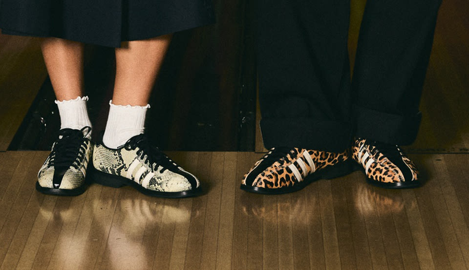 Adidas x Brain Dead collaboration sneakers featuring snake and leopard print patterns, styled with dark wide-leg trousers and white socks on a wooden floor.