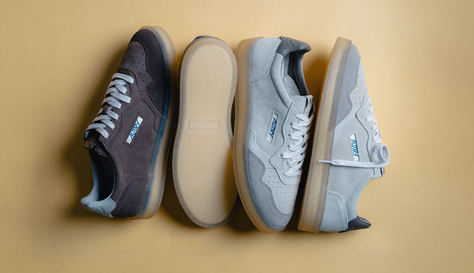 Autry low-top sneakers in grey and light blue suede, displayed from multiple angles on a beige background.