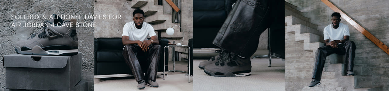 A man wearing a white T-shirt and black leather pants poses in a modern, minimalist interior with concrete walls and stairs. He is wearing dark grey Air Jordan 4 sneakers. One image shows a close-up of the sneakers with detailed stitching and mesh panels, placed on a matching grey shoe box. Another shows the man seated on a black leather couch, and another captures him sitting on a concrete staircase, showcasing the full outfit. The leather pants have a subtle floral embossing on the side.