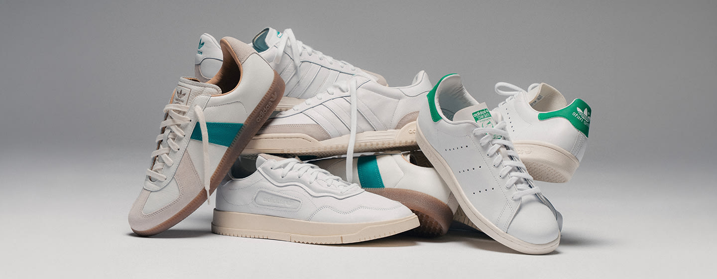 adidas courtpack sneakers in white with green accents, arranged in a clean studio setting. Geben Sie Ihr Feedback zu BizChat ab.