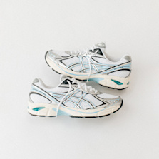 A pair of ASICS GEL 1130 sneakers in white, silver, and teal, laid side by side on a clean background.