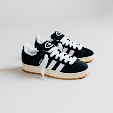 Pair of Adidas Campus sneakers in black suede with white stripes and thick white laces, displayed side-by-side on a minimal white background.