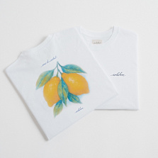 Two white T-shirts, one featuring a watercolor-style illustration of yellow lemons with green leaves and the word 'solebox' printed, the other with just the 'solebox' logo on the chest.