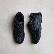 Pair of all-black Nike P-6000 sneakers displayed on a light-colored textured surface.