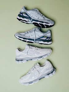“Three pairs of ASICS GEL-NYC sneakers in shades of grey, white, and green, displayed on a light green surface.”